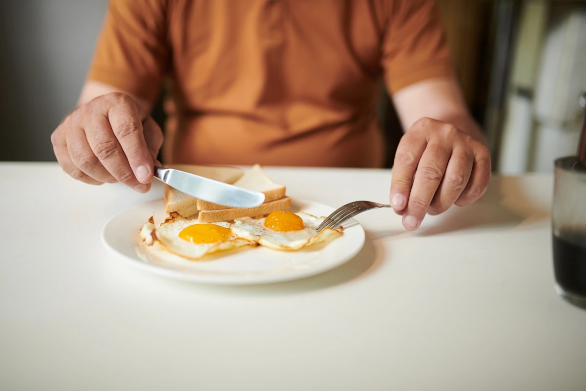 Une personne qui mange des oeufs pour la mémoire et la vitamine