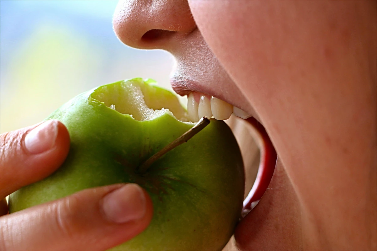 Une personne qui mange une pomme
