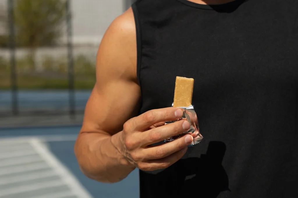 Un homme qui mange une barre sucrée avant le sport