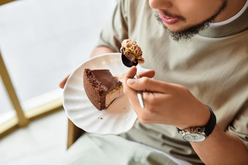 Un homme qui mange un gâteau sucré