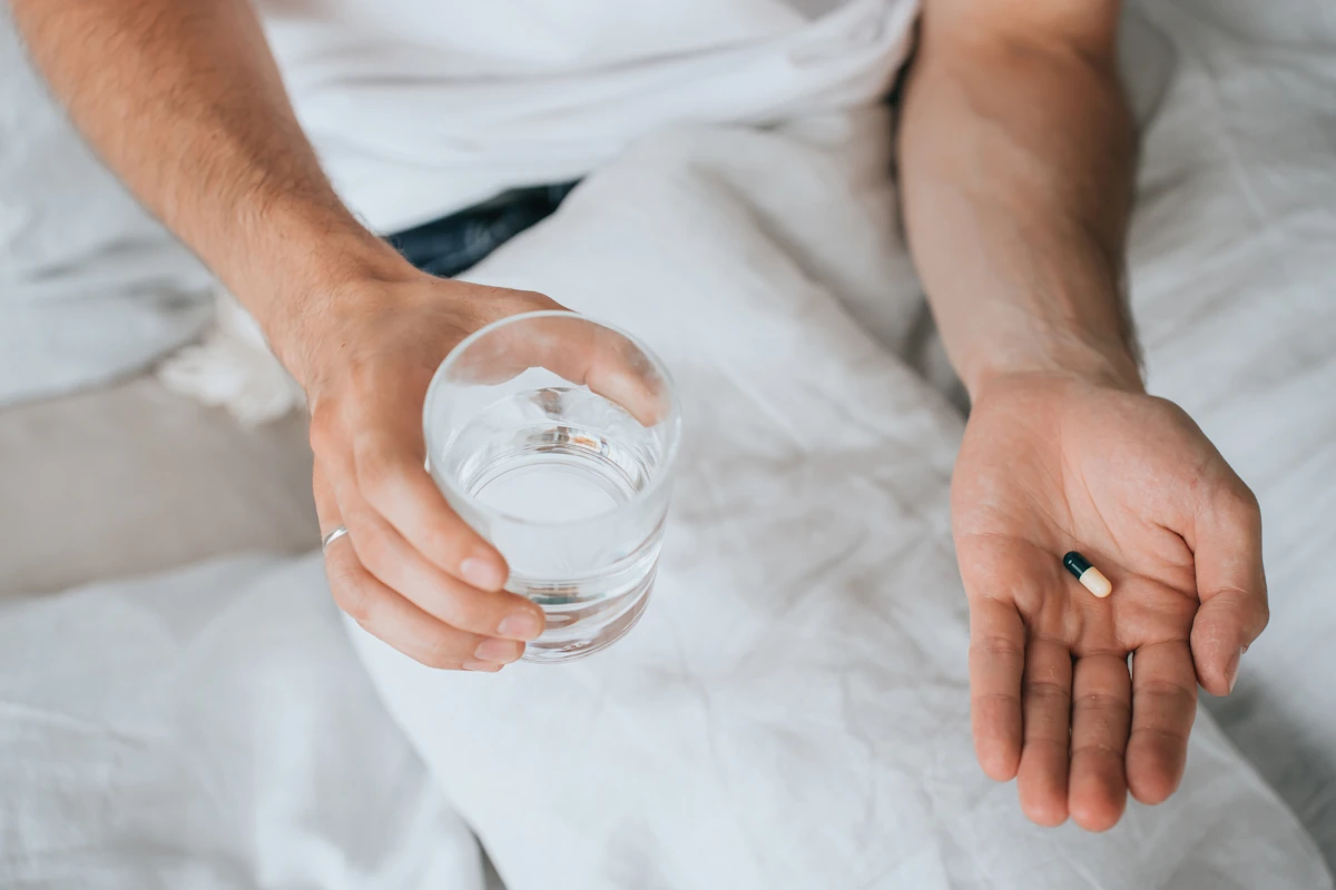 Une personne qui prend des complexes multivitaminées le soir